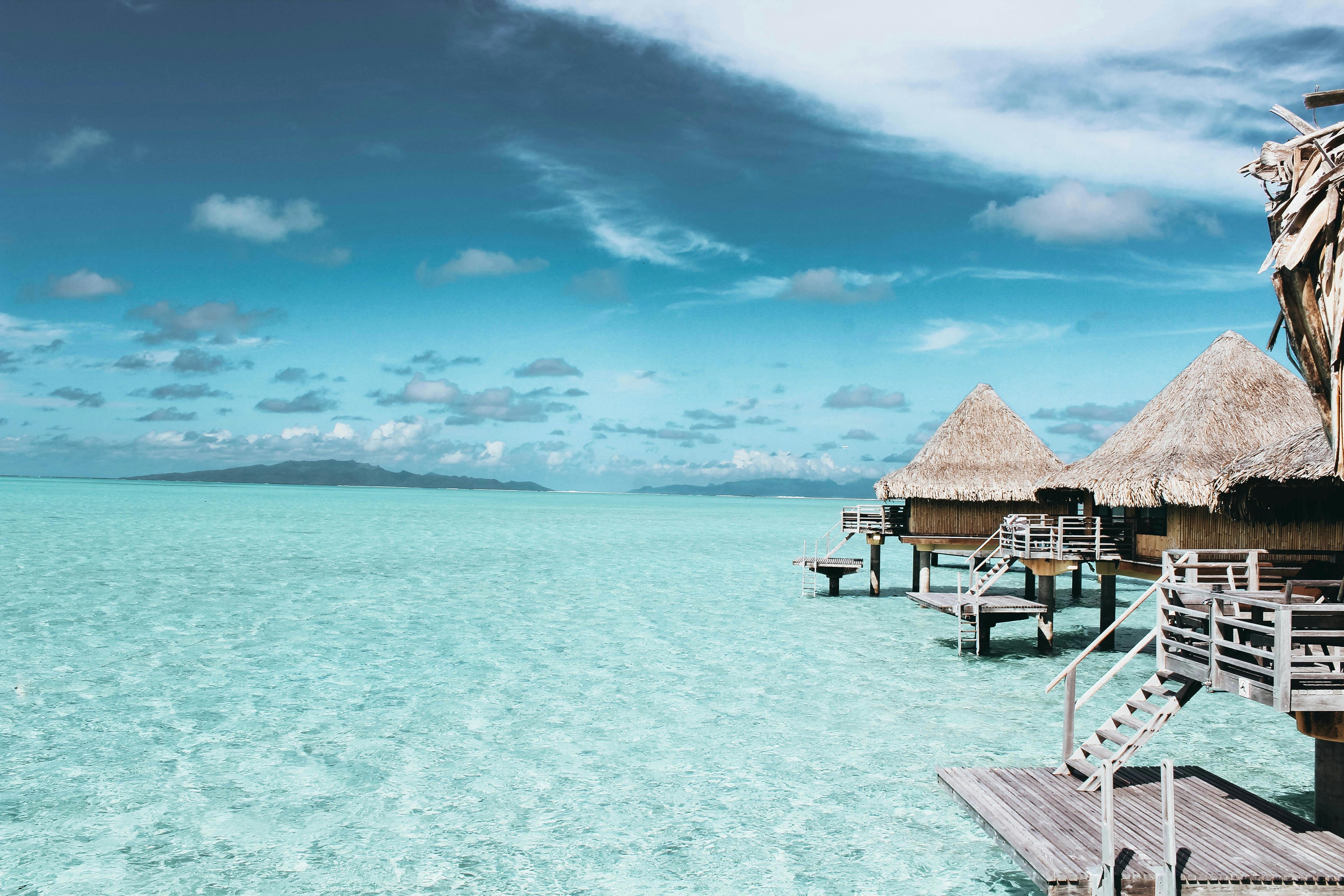 Waterfront huts at low tide Photo by Vincent Gerbouin: https://www.pexels.com/photo/three-brown-wooden-cottage-and-sea-1167021/