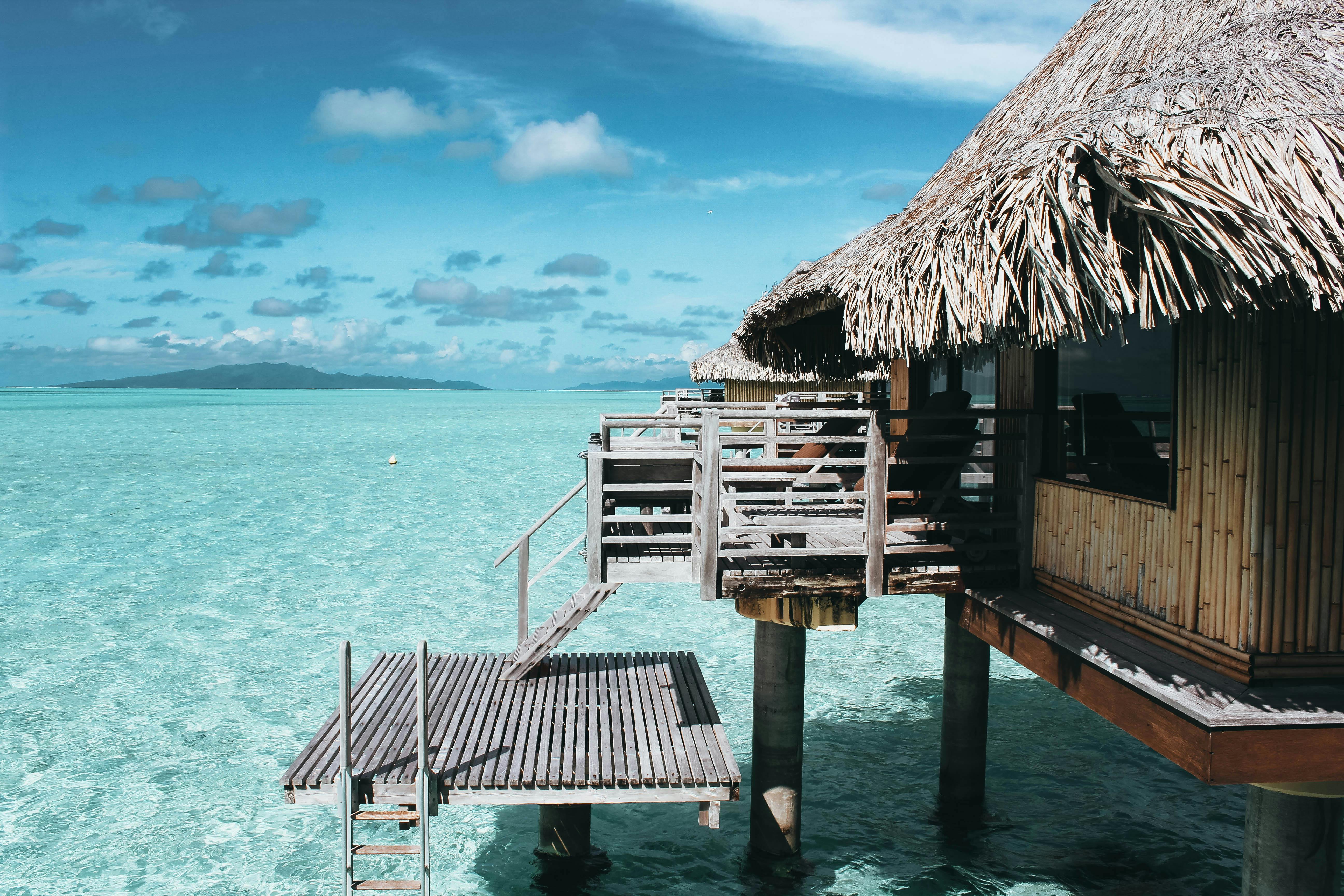 Island hut on the water Photo by Vincent Gerbouin: https://www.pexels.com/photo/brown-nipa-hut-on-body-of-water-1179156/